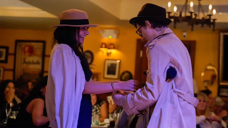 A Murder Mystery Company detective questioning a guest at a Chicago show